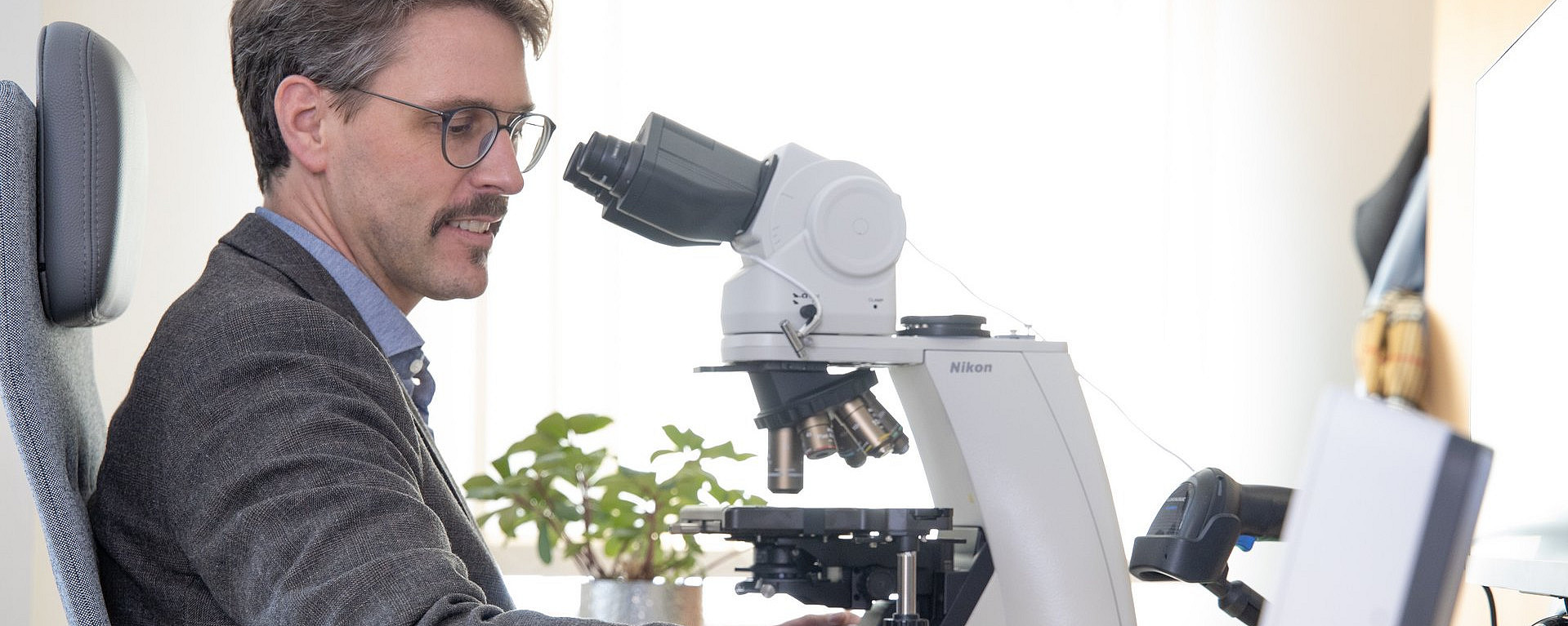 Ein Mann untersucht Proben unter einem Mikroskop